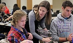 An instructor interacting with a student in the classroom