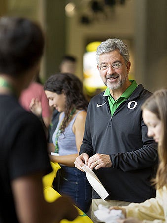 Patrick Phillips talks to a student at the Eugene Migration event.