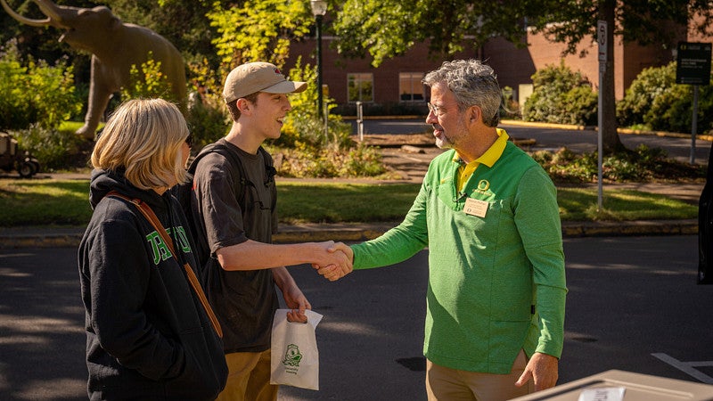 Interim President Phillips talking with a student during Unpack the Quack