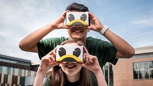 two students wearing UO virtual reality goggles