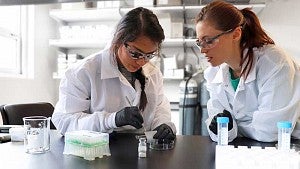 Michelle Hernandez learns testing techniques in a lab with her mentor Kelly Hyland