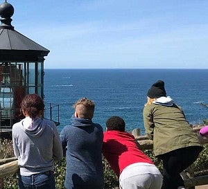 kids looking out at the ocean at a lighthouse