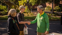Interim President Phillips talking with a student during Unpack the Quack