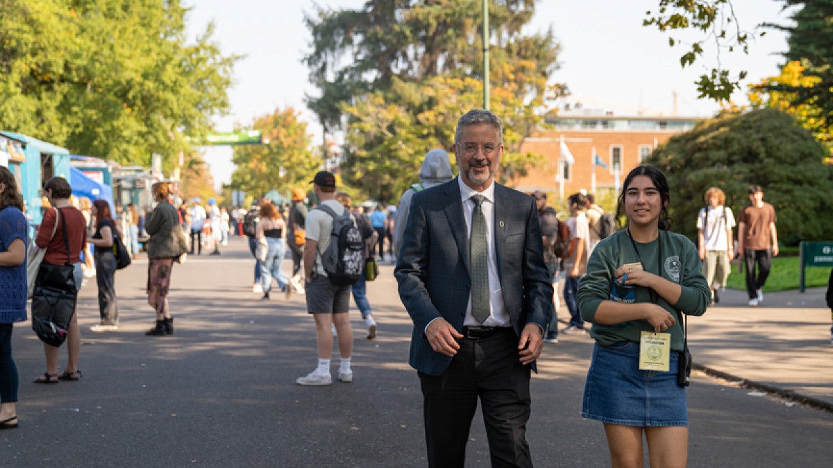 Interim President Patrick Phillips and ASUO Student Body President Luda Isakharov walk down 13th avenue to talk with students and street faire vendors